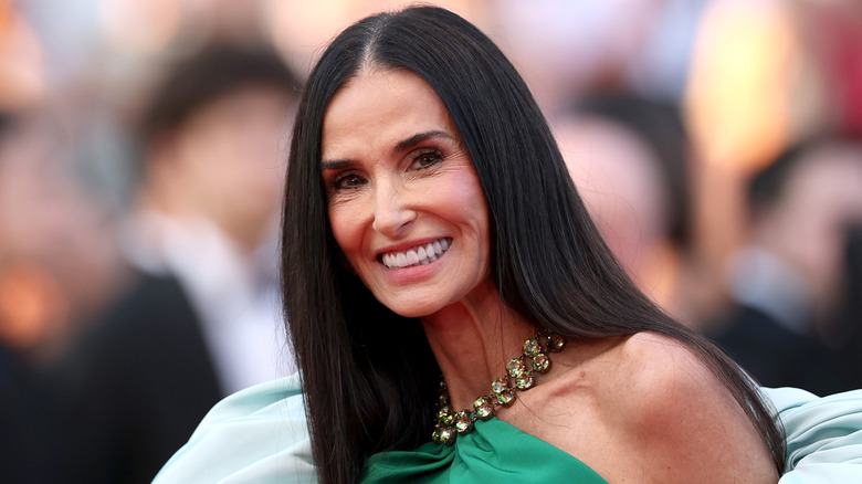 Demi Moore posando con un vestido verde con escote joya en 2026.