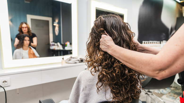 Una mujer con rizos irlandeses cortándose el pelo por parte de un profesional.
