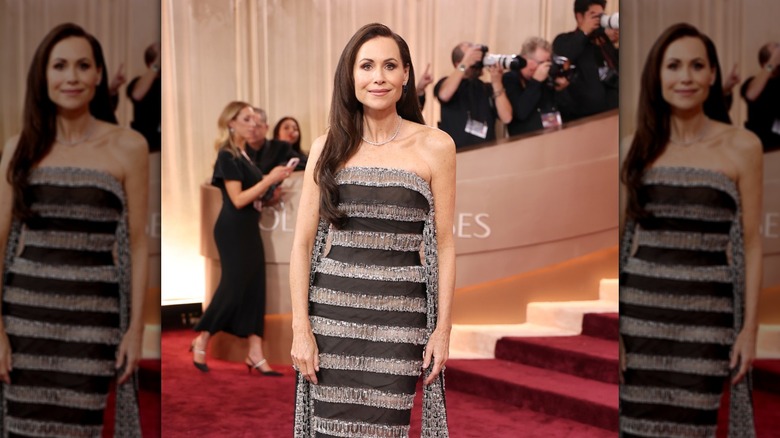 Minnie Driver en la alfombra roja de los Globos de Oro con un vestido sin tirantes a rayas y cabello liso y liso.