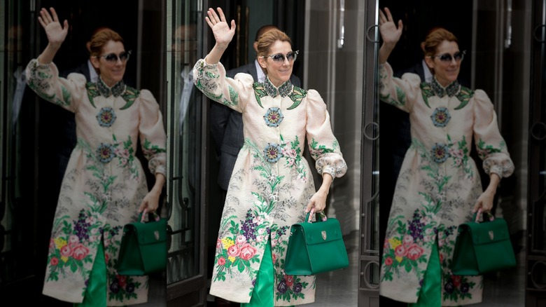 Céline Dion con un abrigo de flores saludando a los fans