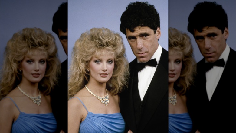 Morgan Fairchild con un vestido azul y un collar de diamantes y Elliott Gould con un esmoquin en una entrega de premios.