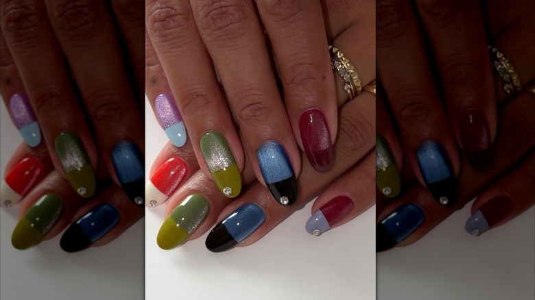Una mano con uñas multicolores.