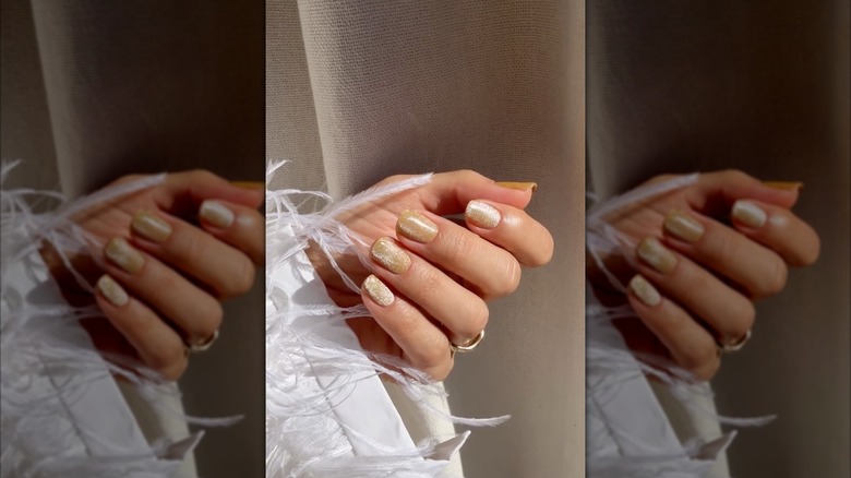 Una mano con uñas de terciopelo color caramelo.
