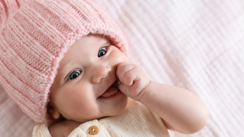 Bebé con gorro de punto rosa.
