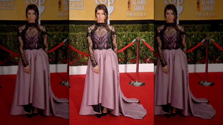 Mayim Bialik posa con un vestido malva con encaje negro.