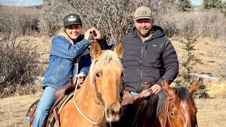 Amber y Shawn Marshall posan para una foto creando un corazón con sus manos durante un paseo a caballo