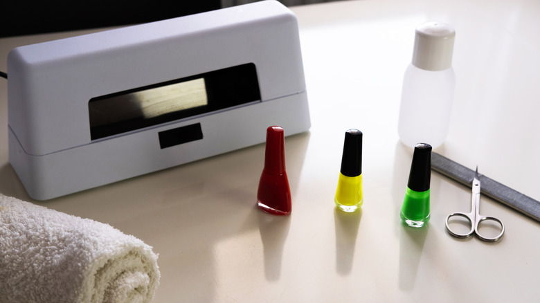 Productos necesarios para una manicura en gel, incluido esmalte en gel y una lámpara LED.