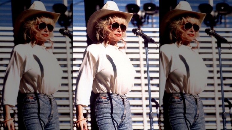 Dolly Parton vestía un top blanco, un sombrero de vaquera a juego y jeans.