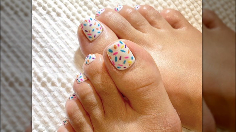 Una pedicura con un diseño tipo confeti multicolor