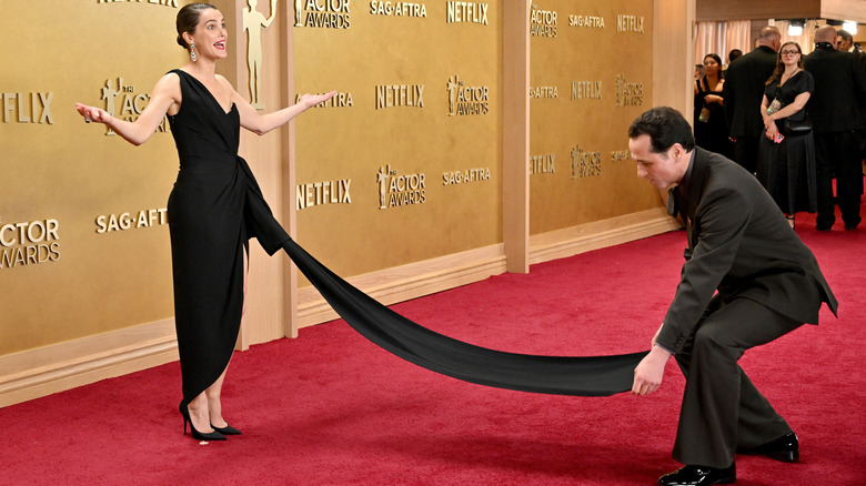 Keri Russell posa en la alfombra roja mientras Matthew Rhys arregla la cola de su vestido