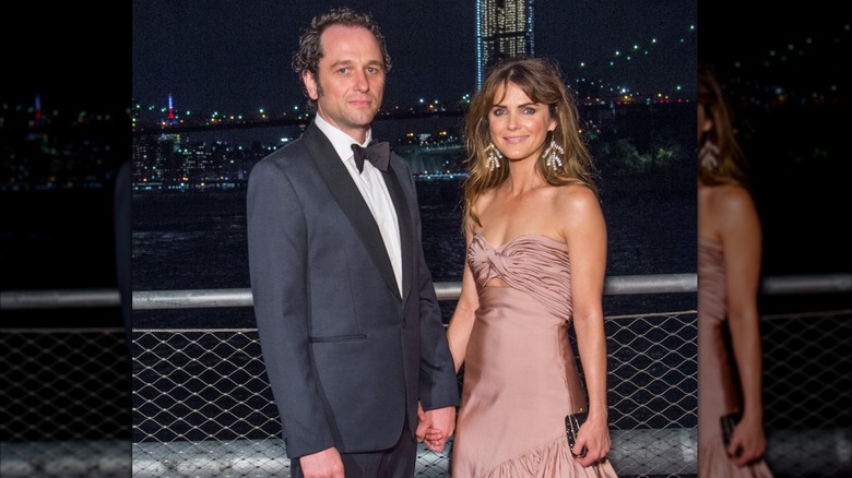 Matthew Rhys y Keri Russell se toman de la mano mientras posan en un evento en Brooklyn, Nueva York.