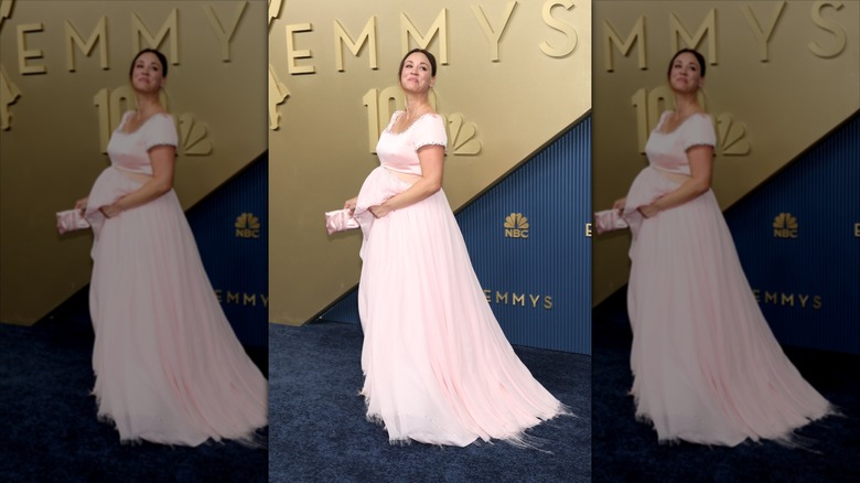 Kaley Cuoco sonríe con un vestido rosa recortado con panza