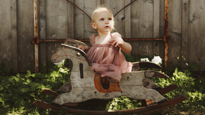 Una niña en un caballito de madera vintage