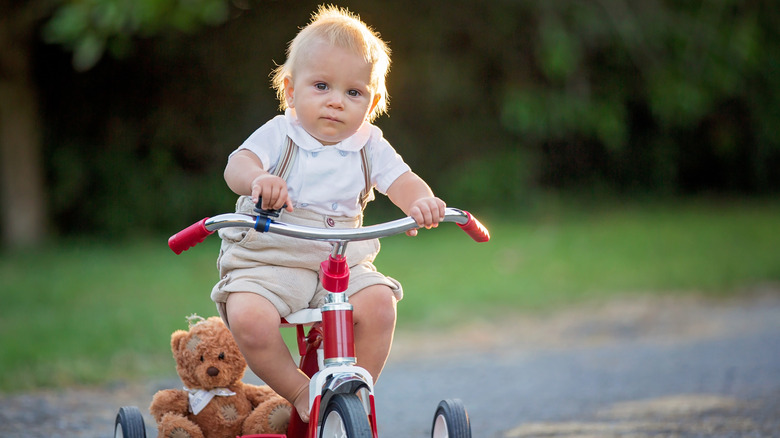 Un niño pequeño montado en un triciclo