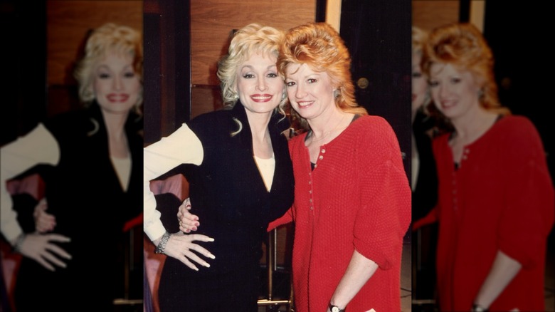 Dolly Parton (izquierda) con Judy Ogle (derecha) con cabello pelirrojo alborotado y un vestido rojo con botones.