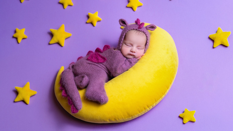 Niña con un mono de dragón durmiendo