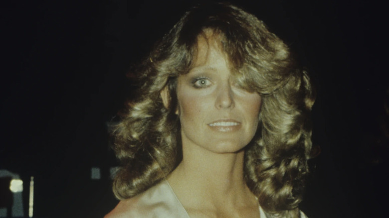 Una fotografía de Farrah Fawcett la muestra con un gran cabello rizado que cubre parcialmente su rostro.