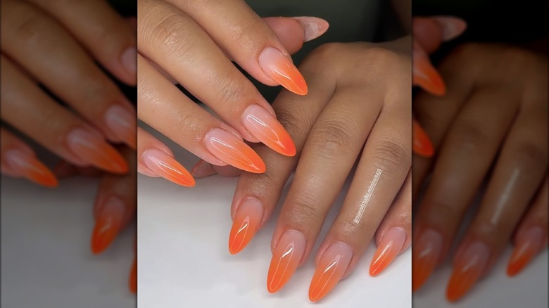 Manicura larga y redondeada con puntas francesas ombre naranja.