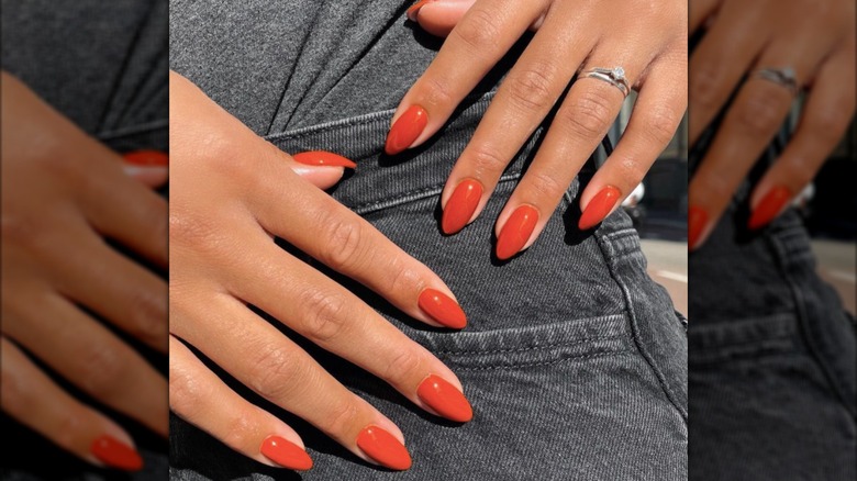Manicura almendrada con esmalte de uñas naranja quemado.