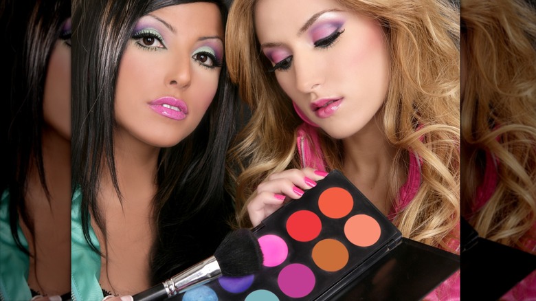 Dos mujeres mostrando una colorida aplicación de sombra de ojos y una paleta al estilo de los 80
