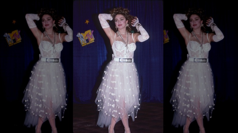 Madonna fotografiada en 1984 con un traje de encaje blanco, falda transparente y guantes blancos.