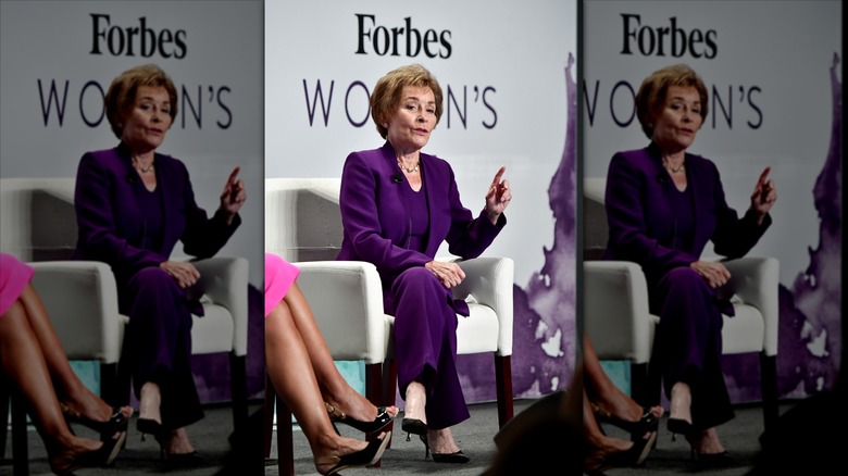 Judy Sheindlin con un traje pantalón color ciruela.