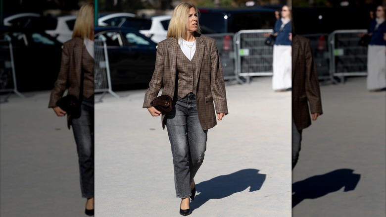 Una mujer vestida con chaleco y chaqueta con jeans y camiseta.