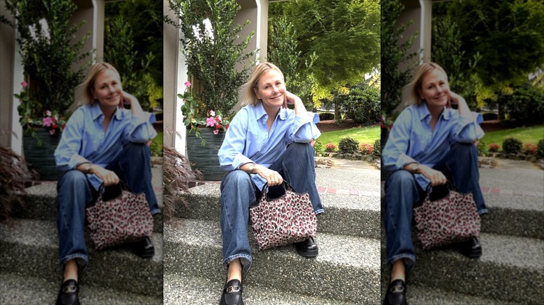Lynette Marcus vestida con camisa y jeans, y sosteniendo un atrevido bolso con estampado de leopardo.