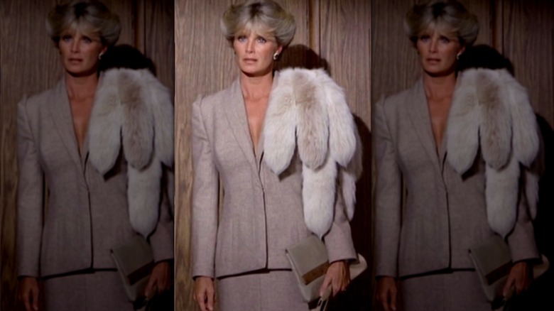 Linda Evans fotografiada como Krystle Carrington en Dynasty con una chaqueta, una falda y un chal de piel.