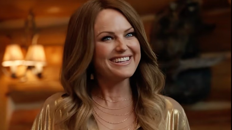 Se ve a la actriz Malin Akerman con una peluca morena durante una escena de The Hunting Wives de Netflix.