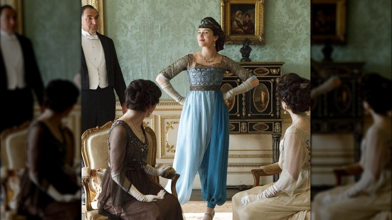 Jessica Brown Findlay como Lady Sybil con pantalones harén turquesa y una diadema marrón