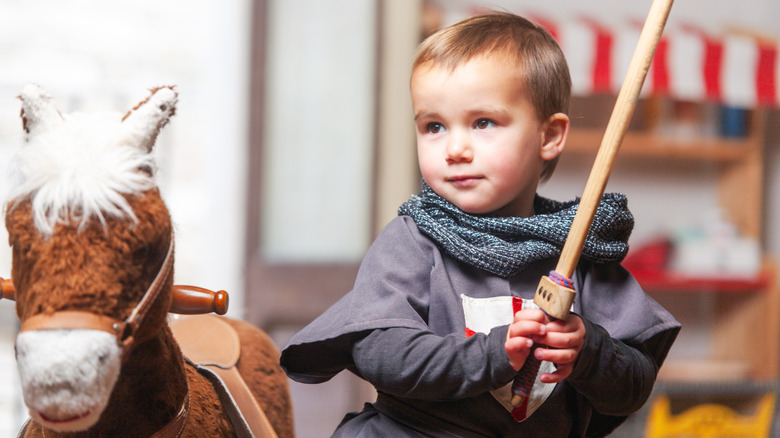 Un niño pequeño jugando con una espada de juguete.