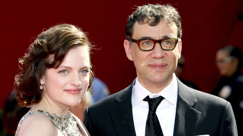 Elisabeth Moss y Fred Armisen observan mientras son fotografiados juntos en un evento de alfombra roja.