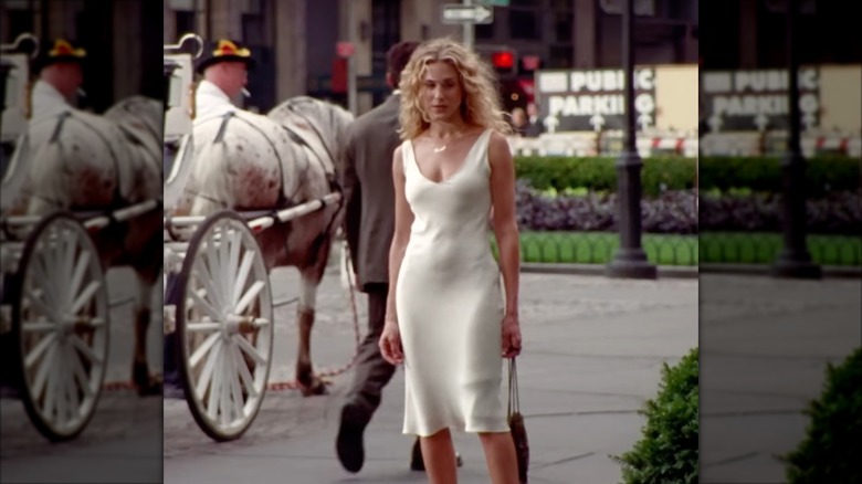 Sarah Jessica Parker como Carrie Bradshaw con un vestido lencero de satén blanquecino.